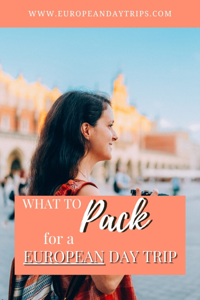 A smiling woman with long dark hair, wearing a red patterned dress and carrying a camera, stands in a sunny European square with blurred historic architecture in the background. Overlaid text reads “What to Pack for a European Day Trip” with the website URL europeandaytrips.com displayed at the top.