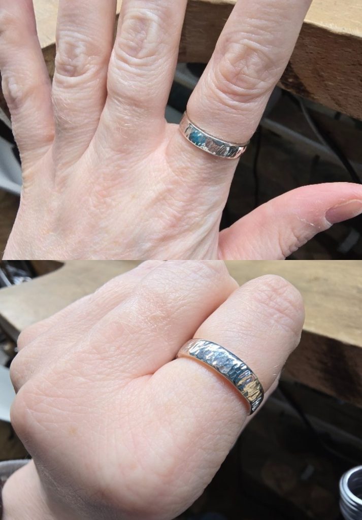 Close-up views of a hand wearing a wide silver ring with a hammered texture, shown from different angles to highlight the ring’s reflective surface and handcrafted detailing.