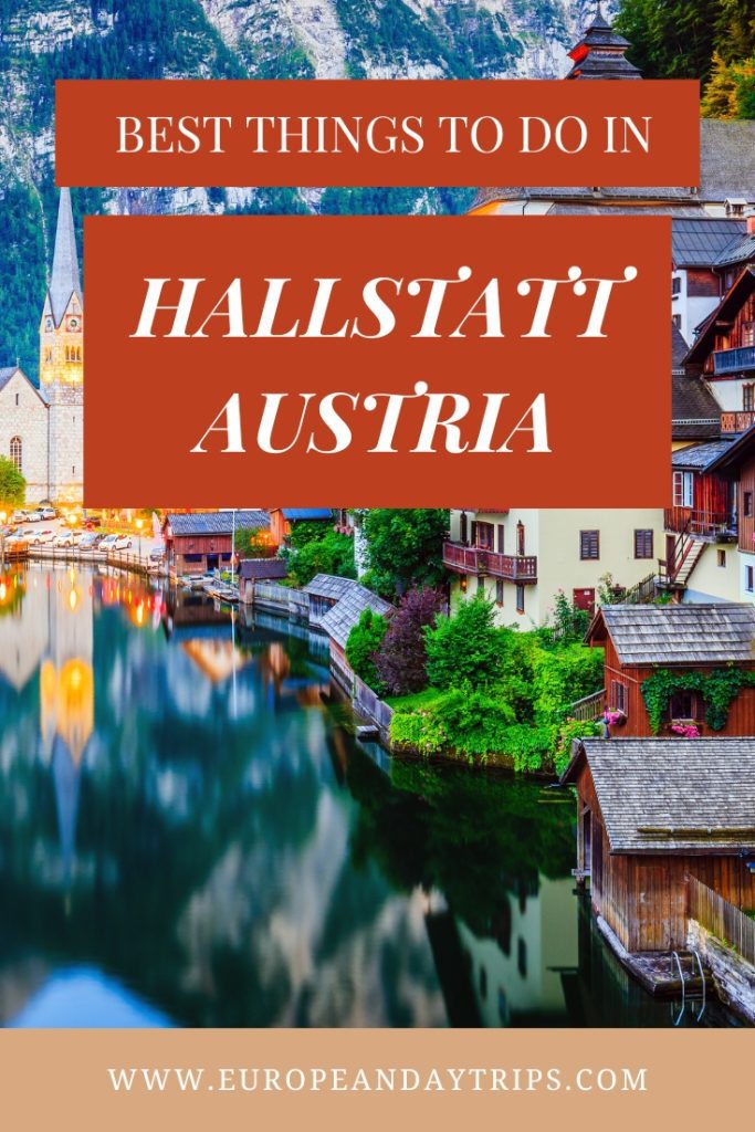 Colorful lakeside village of Hallstatt, Austria with traditional alpine homes, a church spire, and mountain reflections in the calm water, overlaid with bold text reading “Best Things to Do in Hallstatt Austria” and the website “europeandaytrips.com.”
