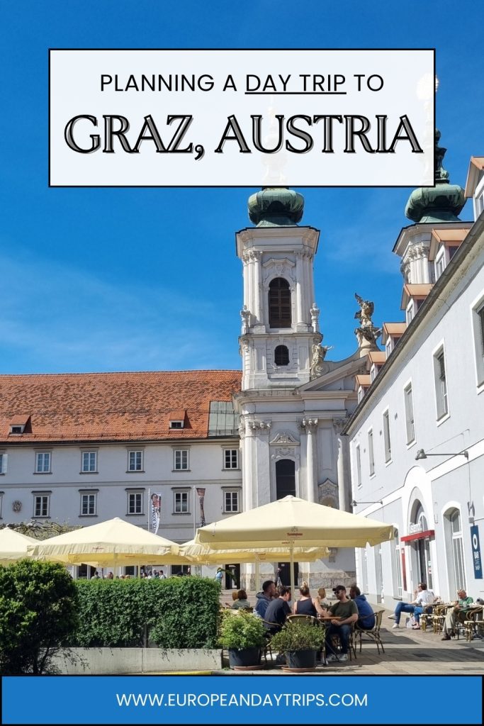 Outdoor café tables with yellow umbrellas in a sunny square in Graz with a white baroque church tower rising behind them. Text overlay reads "PLANNING A DAY TRIP TO GRAZ, AUSTRIA" and "WWW.EUROPEANDAYTRIPS.COM