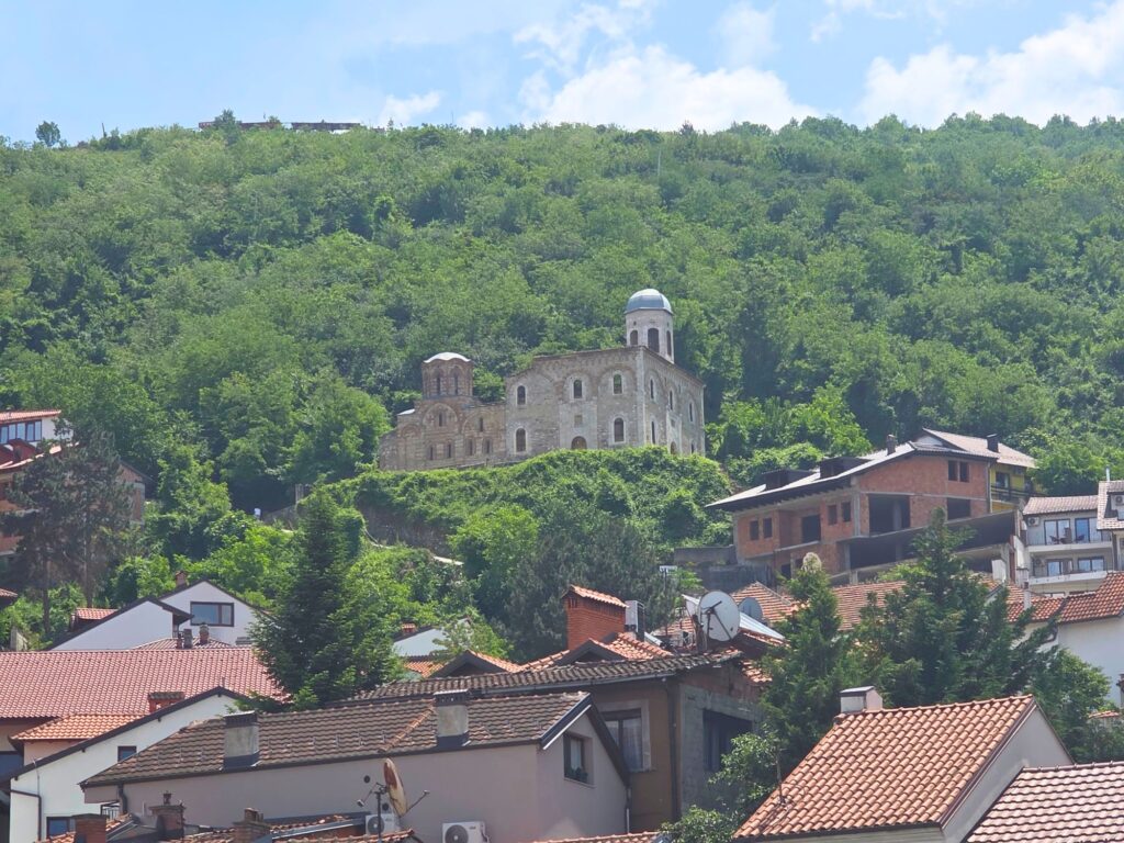 Church of the Holy Saviour on a wooded hillside above the red-roofed houses of Prizren.