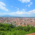 View from Prizren Fortress over the city’s red rooftops, mosques and river, with mountains in the distance, Kosovo.
