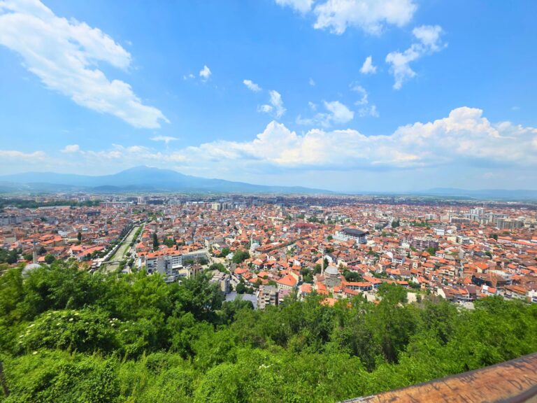 View from Prizren Fortress over the city’s red rooftops, mosques and river, with mountains in the distance, Kosovo.